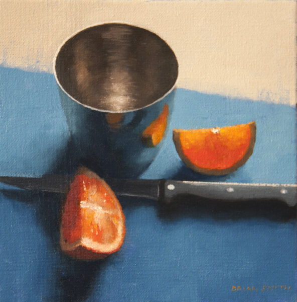 Sliced orange and metal cup